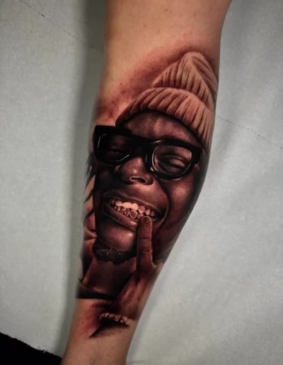 Ritratto sorridente con berretto, tatuaggio realistico - Andrew Lead, Keyo Tattoo Studio Locarno