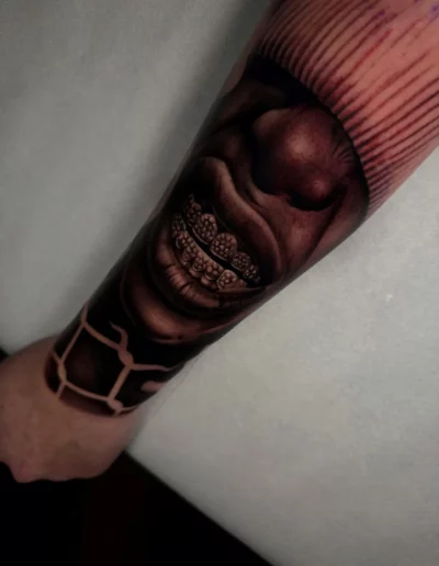 Sorriso con apparecchio, tatuaggio realistico sull'avambraccio - Andrew Lead, Keyo Tattoo Studio Locarno